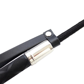 Närbild av Latetobed Riding Crop 66 cm, med svart design med silverfärgad metallaccent och flätad handtagsögla - perfekt för BDSM och dominanslekar.