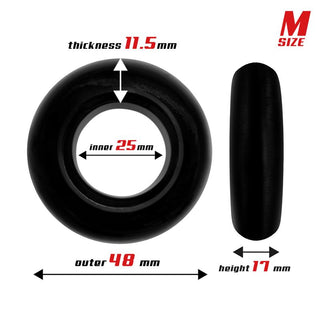 Illustrationen visar en svart ring i storlek M från Beast Cockring Set 3-Pack, med en ytterdiameter på 48 mm, innerdiameter på 25 mm, tjocklek på 11,5 mm och höjd på 17 mm. Den är tillverkad av kroppssäkra material och har röd textmärkning.
