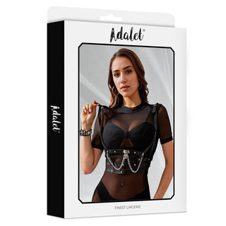 Kvinna i skira svarta underkläder bär Thalia Vegan Leather Harness med kedjedetaljer och eleganta detaljer i veganskt läder, avbildad mot Adalet Lingerie vita förpackning.