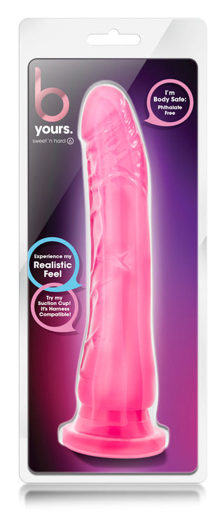 Rosa realistisk dildo i mjukt material med sugkopp och harnessbas, visas förpackad.