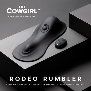 Cowgirl Rodeo Rumbler Ride-On är en elegant svart vibrator med trådlös fjärrkontroll för handsfree njutning, som visas på en minimalistisk svart bakgrund.