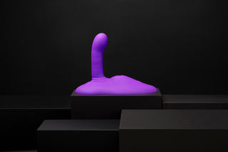 En lila, abstrakt Cowgirl Rodeo Rider Thrusting-skulptur i kroppssäkert silikon står upprätt på en svart plattform mot en mörk bakgrund.