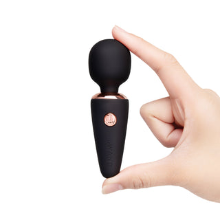 Le Wand Mini Micro Wand, en kompakt svart vibrator med accenter i roséguld, slät yta, visas på en vit bakgrund.
