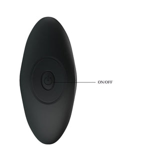 PrettyLove Vibrerande Analplugg i svart, oval form med ON/OFF-knapp i mitten. Tillverkad av kroppssäkert silikon och erbjuder 12 vibrationsfunktioner. Placerad på vit bakgrund.