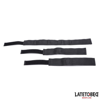 Tre svarta Collar With Wrist Restraints, tillverkade av slitstark nylon med justerbara handtag och kardborreband, visas sida vid sida mot en vit bakgrund.