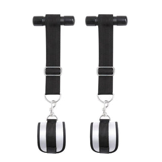 Ett par svarta och silver justerbara ankel- eller handledsremmar med metallklämmor, med i det fascinerande IntoYou Door Restraint Kit.