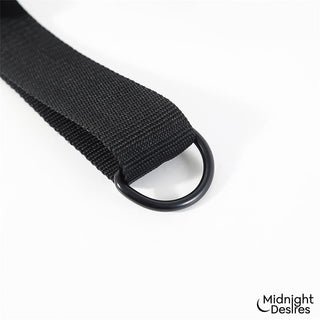 Svart justerbar Restriktionsset med nackstöd och rem med en D-ring i metall, tillverkad av syntetmaterial; logotypen syns tydligt.