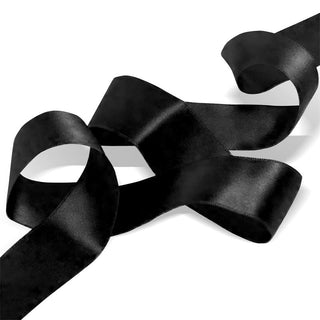 Ett löst Satin Bondage Ribbon slingrar sig på en vit bakgrund, perfekt för silkeslena bondagescener eller tillsammans med en ögonmask handbojor.