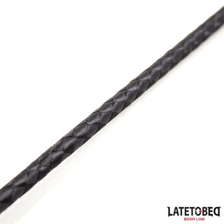 Närbild av Svart BDSM Piska 60cm PU Läder, en svart flätad piska tillverkad av veganskt PU-läder, med LATETOBED BDSM LINE-logotypen i det nedre högra hörnet.