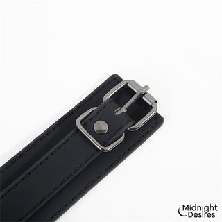 Set med halsband och fotbojor i svart veganskt läder med silverfärgat spänne, i minimalistisk design.