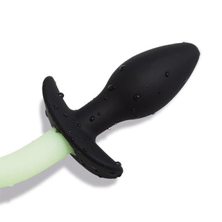 Glow in the Dark Tail Buttplug har svart silikon med vattendroppsdetaljer och en ljusgrön bas, perfekt för lek med valpar. Visas på en vit bakgrund.