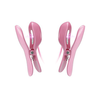 Två rosa plasthårklämmor med en böjd design, med metallgångjärn och en genomskinlig sektion, liknar den milda vibrationen hos E-Stim Bröstklämmor Med Vibration.