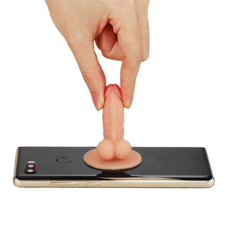 En persons hand rör vid en ny telefonhållare designad som en miniatyrfigur på baksidan av en smartphone, kallad Penis Mobilhållare.