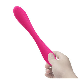 En hand som håller PrettyLove Yedda Bendable, en ljusrosa C-formad vibrator för G-punkt och klitorisstimulering, mot en vit bakgrund.