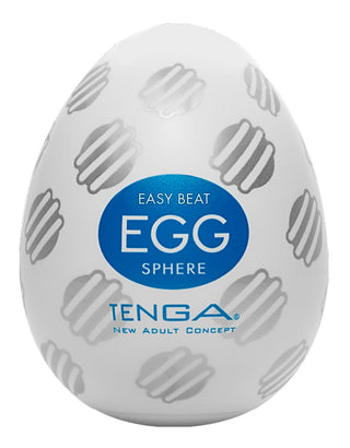 Vitt, äggformat föremål med gråa mönster och en blå etikett med texten "Tenga Egg Sphere" - ett TENGA onaniägg (onaniägg) för engångsbruk från serien New Adult Concept.