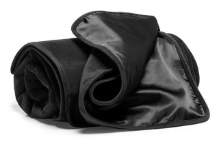 Vinyllakan Liberator är en sofistikerad svart satin- och sammetsfilt med silkeslena kanter, perfekt för att lägga till en elegant touch som en sexiga täcke.