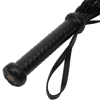 Vi presenterar Fifty Shades of Grey Flogger: ett svart lädermästerverk för sensuell dominans. Med ett texturerat cylindriskt handtag, flera lädersvansar och en handledsrem med fast grepp, är den perfekt för att omfamna dina fantasier.