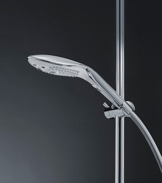 Womanizer Wave, med sin eleganta handhållna design i krom och med Pleasure Jet-teknologi, är stilfullt monterad på en vägg mot en mörk bakgrund.