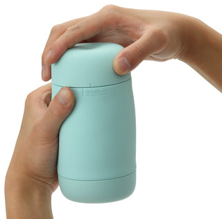 Händer som håller en mintgrön Tenga Puffy Masturbator, med mjuk silikondesign och subtil logotyp.