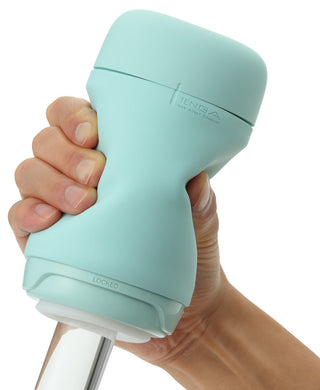 En hand håller den mintgröna Tenga Puffy Masturbator, som är designad med en ergonomisk mjuk silikondesign och massagetexturer. Enheten har märket "Locked" och en synlig glidmekanism.