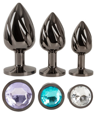Metall Butt Plug Set har tre metalliska pluggar i olika storlekar, idealiska för anal stretching och temperaturspel. Varje plugg har en avsmalnande design med en juvelliknande sten vid basen: en är lila, en annan kricka och den tredje klar.