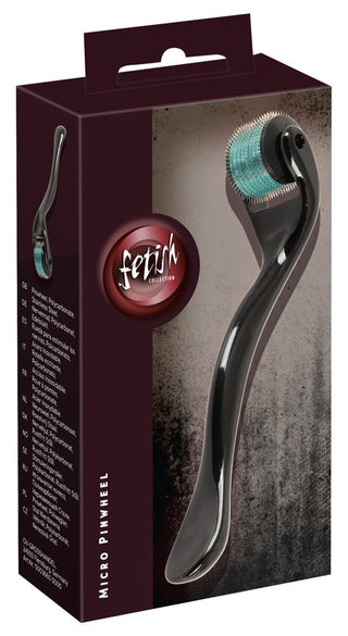 Det kompakta "Fetish Collection"-hjulet, kallat Micro Pinwheel, har en kartongförpackning med en bild av dess eleganta, svarta handtag och slitstarka rostfritt stålhjul med många små nålar, tillsammans med produktnamnet och detaljerna på framsidan.