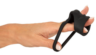 En hand med två fingrar införda i Erecto Cock Sleeve Ball Ring, en svart silikonhylsa med en fäst ögla.