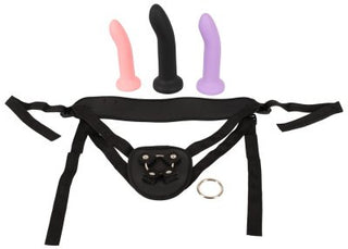 Strap-on Set med 3 Silikondildos" inkluderar en svart justerbar sele med tre utbytbara flytande silikonfästen i rosa, svart och lila. Setet har en metallisk O-ring och visas mot en vit bakgrund.