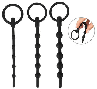 Urethral Dilator Set 3-pack innehåller tre svarta silikonleksaker med graderade pärlformer och cirkulära handtag, perfekt för avancerade användare. En infällning visar en hand som håller en leksak, vilket framhäver dess flexibilitet och lämplighet för urinrörsstimulering.