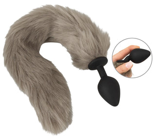 Fluffy Tail Buttplug erbjuder en lekfull upplevelse med sin långa, fluffiga grå svans, perfekt för cosplay eller husdjurslek. En cirkulär infällning visar en hand som håller i kontakten och framhäver dess storlek och form för en perfekt passform.