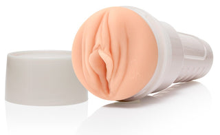 Fleshlight Girls Sky Bri Celestial är en handhållen, vit cylindrisk enhet med locket borttaget för att avslöja en kötttonad interiör som liknar människans anatomi. Kepsen sitter bredvid den på en vanlig vit bakgrund.