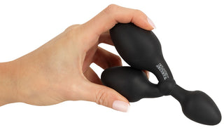 En hand håller Black Velvets Träningsplugg 3-i-1, en svart uppblåsbar analplugg i silikon med logotyp, perfekt för analträning eller att utforska nya sensationer med sin mångsidiga 3-i-1-design.