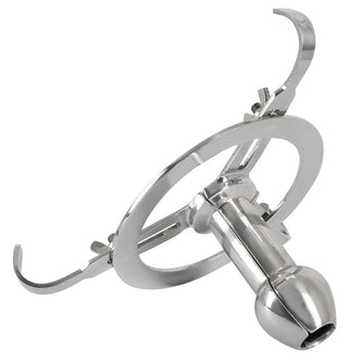 Anal Spreader Deluxe Stål, en medicinsk sårhake i rostfritt stål med böjda armar och cirkulärt handtag, mot en vit bakgrund.
