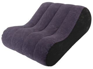Uppblåsbar kilkudde i lila och svart sammet med en böjd, segmenterad ergonomisk design.