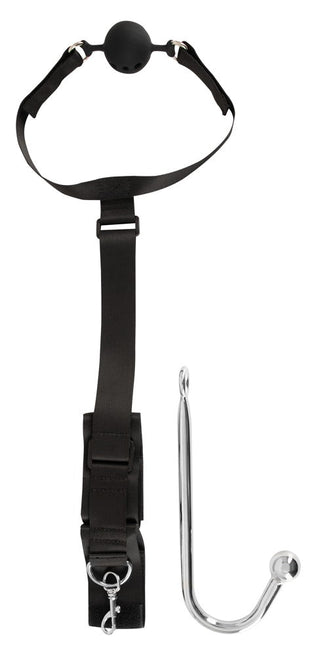 Svart munkavle, svart fästrem med ring och analhake i rostfritt stål, presenterade som ett bondage-set.