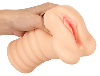 Nature Skin-masturbator för vaginan i beige, med realistisk vulvadesign och en räfflad bas, tillverkad av mjukt silikonliknande material.