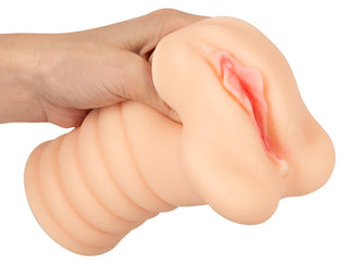 Nature Skin-masturbator för vaginan i beige, med realistisk vulvadesign och en räfflad bas, tillverkad av mjukt silikonliknande material.