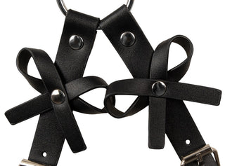 Svart sel i imitationsläder med handbojor, nitar och en metallring upptill.