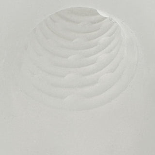 En cirkelformad fördjupning med koncentriska åsar i vitt pulver, som liknar ett fingeravtryck eller en krater, ungefär som den strukturerade ytan på Rebel Penissleeve Med Kulring.