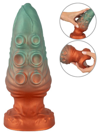 Beasty Cocks Atlantis Buttplug är en grön och kopparfärgad fantasileksak i flytande silikon med runda fördjupningar, som visas när den kläms i två infällda bilder.