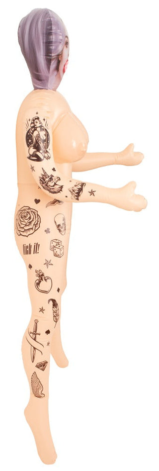 Tatuerad sexdocka i silikon med lila hår, visad i profil mot vit bakgrund.