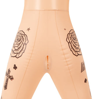 You2Toys Tatuerad Sexdocka iförd svarta latexbyxor, med ros- och korstatueringar, med en vertikal öppningsdesign.