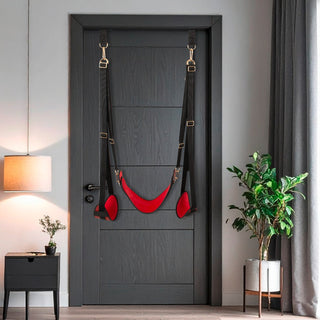 Svart och röd ”Bad Kitty Door Swing” tillverkad av tyg och metall, avbildad hängande på en mörk trädörr.