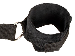 Svart nylon-fästset för montering över dörren, med justerbara handledsbojor fodrade med fuskpäls och D-ringar.