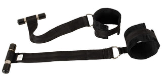 Svart nylon-fästset för montering på dörren, med justerbara remmar, handbojor, handtag och metallringar.