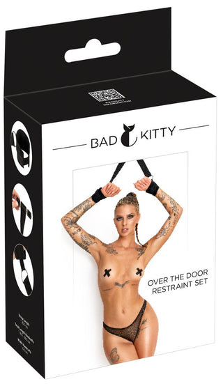Förpackning till ”Bad Kitty Over The Door Restraint Set” som visar svarta justerbara remmar med manschetter och fästbeslag för användning på dörrar.