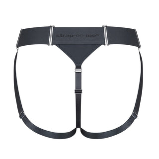 Svart strap-on harness-jock med justerbar midja och två benremmar, tillverkad av syntetmaterial, visas på vit bakgrund.