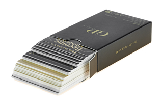 En bunt spelkort från Guilty Pleasure Erotisk Kortlek dras delvis ut ur sin svarta låda märkt med produktnamnet.