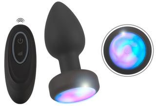 LED Buttplug med Vibration är en svart, fjärrstyrd analplugg med vibration och en glödande flerfärgad LED-bas, som visas från två vinklar.