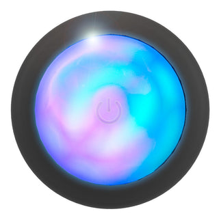 Ett glödande klot med blå och rosa virvlar, omgivet av en mörk ring och en subtil kraftsymbol, som påminner om LED Buttplug med Vibration.